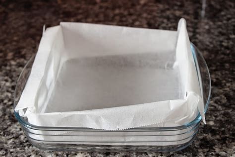 Molde metálico cuadrado forrado con papel de horno, listo para recibir la masa de brownie.