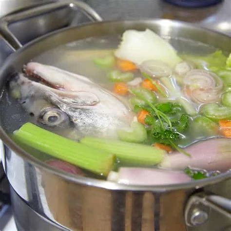 Pescado blanco (espinas, cabezas) y mirepoix de verduras frescas en una olla
