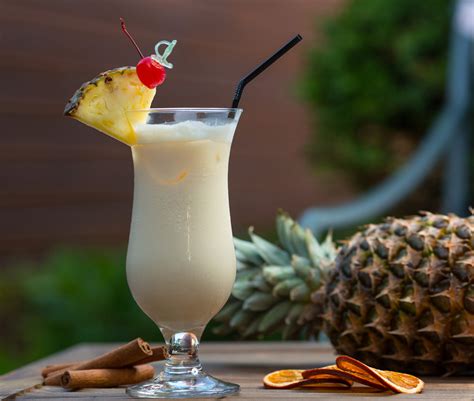Coctel Piña Colada servido en vaso alto con rodaja de piña y cereza