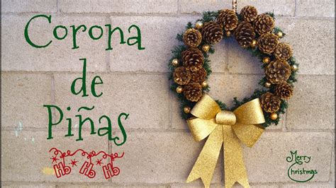 corona de bienvenida hecha con piñas naturales y una percha, decorada con una cinta de rafia