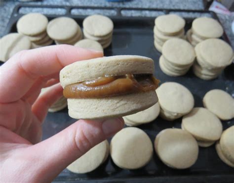 Alfajores siendo bañados en chocolate.