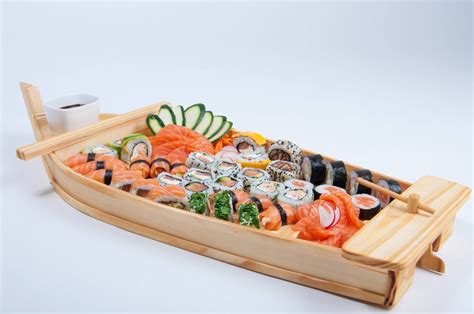 Variedad de barcos de sushi y bandejas de presentación de madera con sushi y sashimi