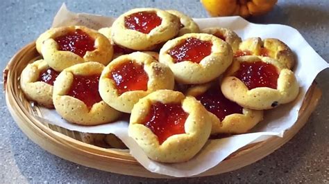 Fotografía detallada de pepas de membrillo recién horneadas sobre una rejilla, mostrando la textura arenosa de la masa y el brillo del dulce.