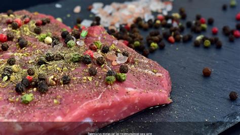 manos adobando filetes de carne con especias