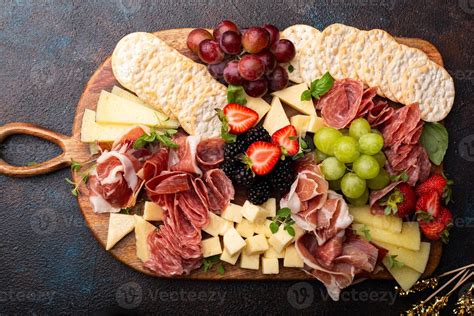 Diseño de tabla de carnes mixta con quesos, embutidos y varios acompañamientos
