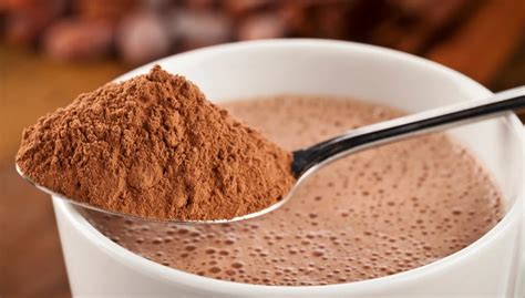 Ingredientes para leche de chocolate casera, incluyendo leche, chocolate en polvo, chocolate en barra, canela, clavo de olor, cascarita de naranja y vainilla