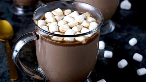 Leche de chocolate caliente decorada con marshmallows y sirope de chocolate