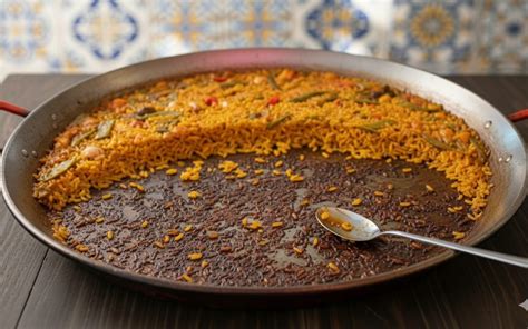 Primer plano de un socarrat perfecto en paella de marisco