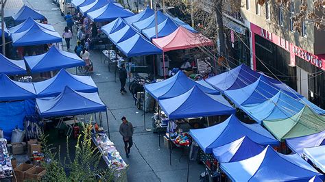 Comercio ambulante con toldos azules en un mercado callejero en Santiago