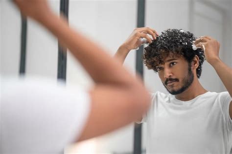 Hombre aplicando gel en sus rizos con la técnica de dedo