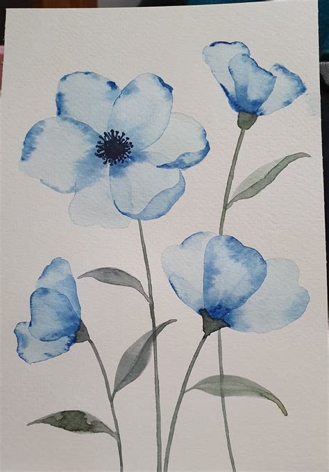 Imagen de una flor de cartón siendo pintada con acuarelas.