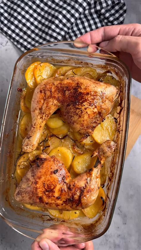 pollo asándose en bandeja de horno con ajos y limón