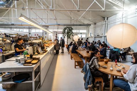 Interior de Alma Nomad Fábrica, mostrando la zona de obrador y mesas para clientes.