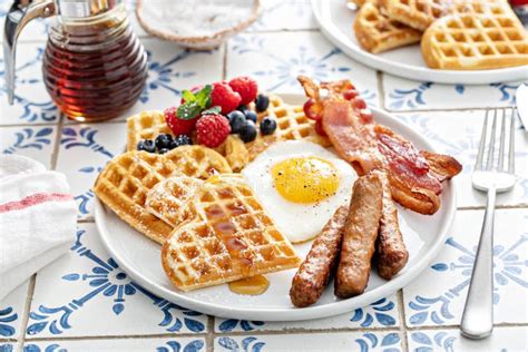 Plato de waffles decorados con miel, ají y tocino, ideal para un desayuno especial.