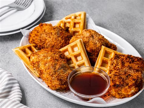 Un waffle salado servido con pollo frito y una salsa cremosa, demostrando su versatilidad.
