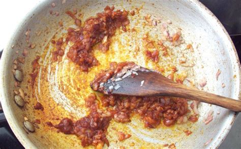 Primer plano del aderezo base con cebolla, ajo y ají panca cocinándose en una olla