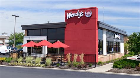 Dave Thomas frente al primer restaurante Wendy's