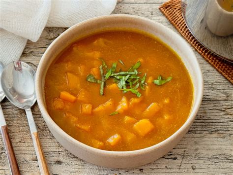 Ingredientes frescos para la sopa de calabaza: calabaza, zanahorias, cebolla, puerro y ajo.