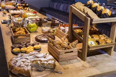 Buffet de desayuno continental en un hotel con panes, frutas y bebidas
