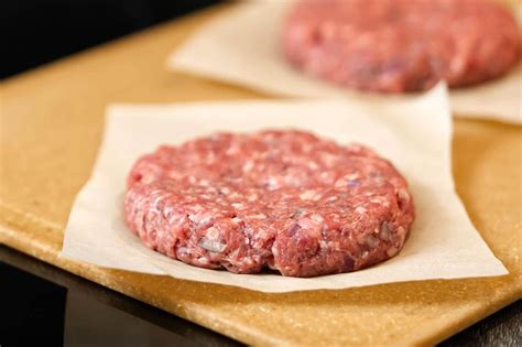 Foto de hamburguesas de carne y avena crudas, listas para cocinar