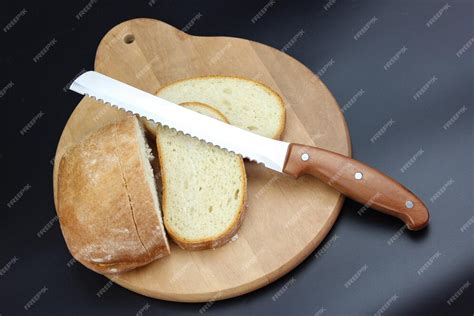 Cuchillo para pan cortando una hogaza de pan rústico.