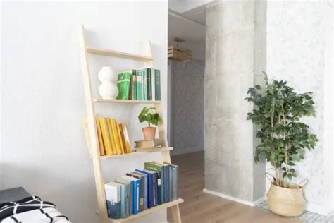 Estantería lineal de madera decorada con libros y plantas en un pasillo moderno.