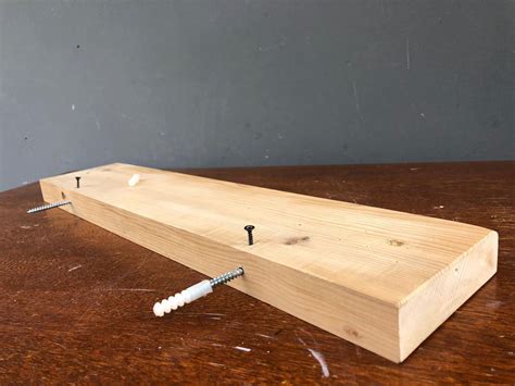 Detalle de la textura de una repisa de madera lacada, mostrando su acabado liso y protector.