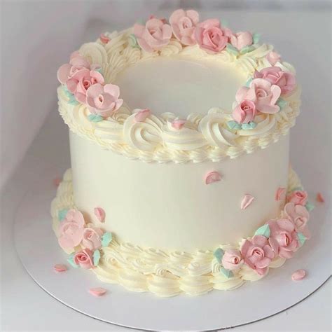 Torta elegantemente decorada con flores y cobertura suave