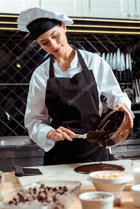 Persona atemperando chocolate en una superficie de mármol con espátula