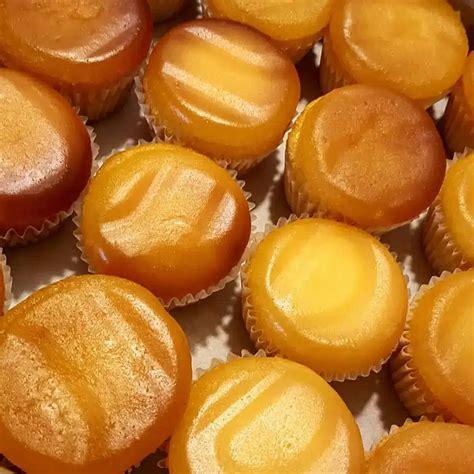 Plato de capuchinos cubanos bañados en almíbar, mostrando su forma de cono y color dorado.