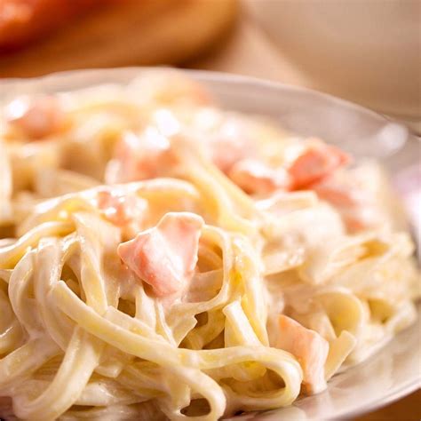 Plato de pasta cremosa con salmón a la plancha y hierbas frescas