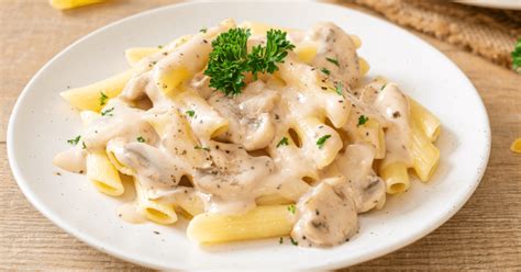 Salsa cremosa blanca para pasta en una sartén, espolvoreada con parmesano
