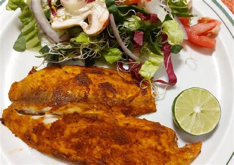 Un plato de carne y pescado marinado con hierbas frescas y especias