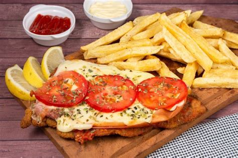 Plato de Milanesa Napolitana con papas fritas y ensalada fresca