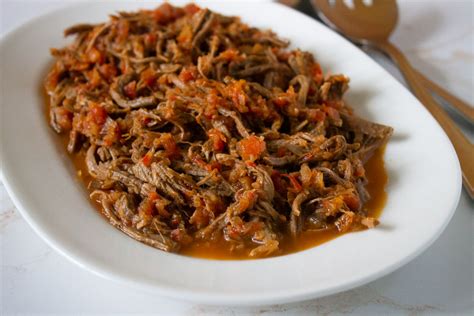 Plato de carne mechada o plateada servido de forma elegante en un restaurante moderno