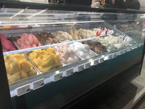 Vitrina refrigerada de heladería con diferentes sabores expuestos.