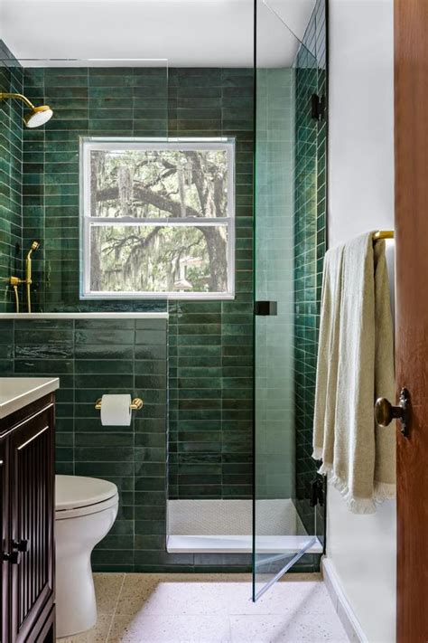 Baño sereno con azulejos verdes y motivos botánicos