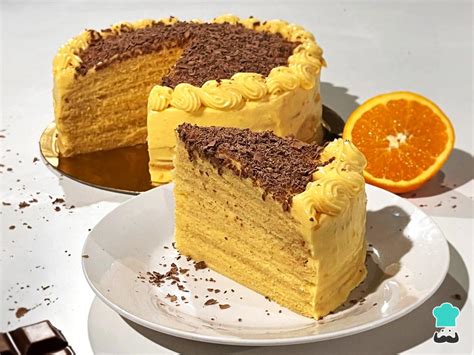 Fotografía profesional de una torta de panqueque con capas finas y un mousse de mango vibrante, decorada con trozos de fruta fresca en la parte superior