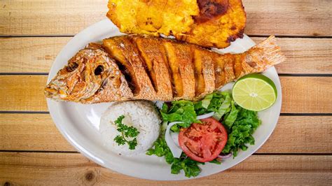 Plato completo de pargo frito con tostones, ensalada y limón