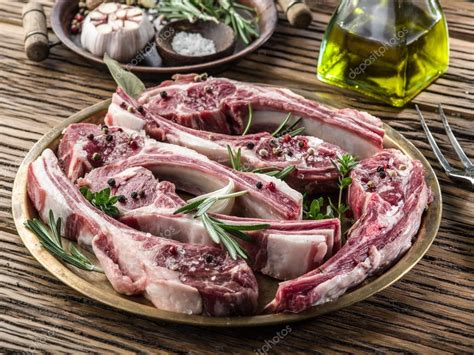 Racimo de costillas de cordero crudas con hierbas frescas y limón