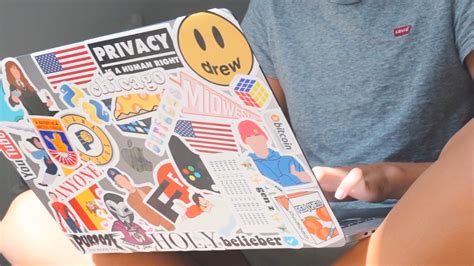 Foto de un MacBook con una cubierta transparente y varias pegatinas