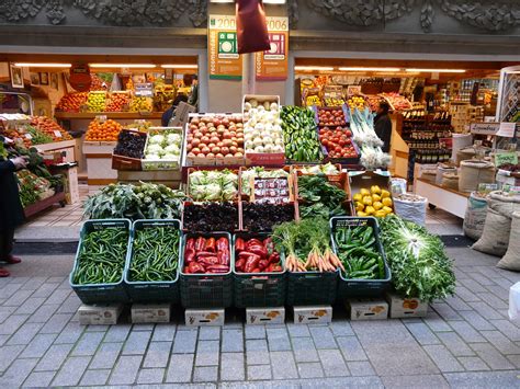 Fotografía de piñas en un puesto de mercado, mostrando diferentes tamaños y colores.