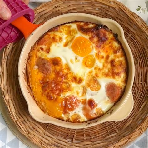 Huevos al horno con rodajas de chorizo y queso derretido en una fuente