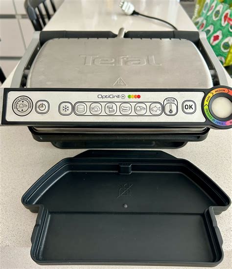 Imagen de la parrilla Tefal Optigrill GC712 mostrando sus placas extraíbles y la bandeja recoge grasas.