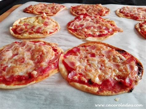 Foto de mini pizzas recién hechas sobre obleas de empanadilla con varios toppings