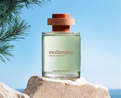 Botella del perfume Mediterráneo de Antonio Banderas y sus ingredientes principales en una disposición atractiva