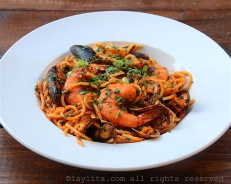 Plato de tallarines con mariscos en salsa de tomate y hierbas frescas