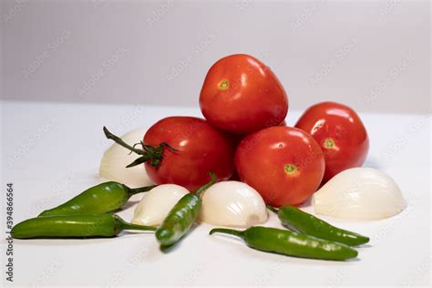 Imagen de aguacates maduros y los ingredientes básicos para guacamole: tomate, cebolla, chile serrano, cilantro, limón.