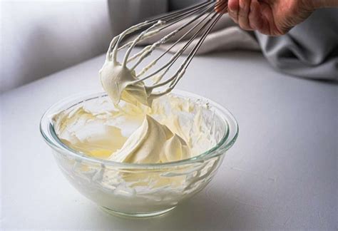 Crema de leche fría siendo batida en un recipiente metálico