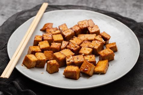 Plato de tofu en cubos y setas shiitake frescas listos para cocinar.